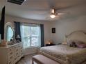 Serene bedroom featuring natural light, a ceiling fan, a comfortable bed, and stylish furnishings at 7133 Sw 135Th Pl, Ocala, FL 34473