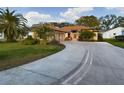 Charming single-story home featuring a well-maintained lawn, mature palms, and a curved driveway leading to the garage at 737 Bolivar St, The Villages, FL 32159