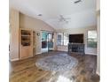 Bright living room featuring hardwood floors, vaulted ceilings with fan, and built-in shelving at 737 Bolivar St, The Villages, FL 32159