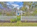 Quaint home framed by blossoming trees and a white picket fence entrance at 815 E 11Th Ave, Mount Dora, FL 32757