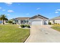 Charming single-story home with manicured lawn, spacious driveway and an attached two-car garage at 909 Abaco Path, The Villages, FL 32163