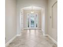Bright foyer features tile floors and a decorative front door with sidelights at 960 Pickering Path, The Villages, FL 32163
