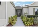 Inviting front entrance featuring a walkway lined with lush landscaping leading to a screen door at 960 Pickering Path, The Villages, FL 32163