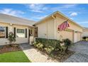 Inviting home entrance with brick walkway, lush landscaping, and American flag displayed at 1037 Green Gate Blvd, Groveland, FL 34736