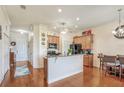 Open-concept kitchen and dining area with granite countertops and hardwood floors at 1037 Green Gate Blvd, Groveland, FL 34736