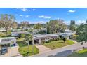 Aerial view of a single story home with carport and mature landscaping in a quiet neighborhood at 1112 Forest Ln, Tavares, FL 32778