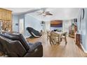 Cozy living room with light blue walls, wood floors, a ceiling fan, and comfortable furnishings at 12221 Helena Ct, Leesburg, FL 34788