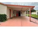 Carport area featuring salmon colored surface and home's entry doors at 1234 E Schwartz Blvd, The Villages, FL 32159