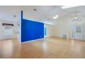 Bright living room with vaulted ceilings, skylights, light wood floors, and a bold blue accent wall at 13219 Meadowlark Ln, Orlando, FL 32828