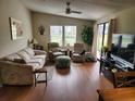 Cozy living room with wood flooring, comfortable seating, and a sliding glass door at 1336 E Schwartz Blvd, Lady Lake, FL 32159