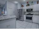 Well-lit kitchen featuring stainless steel appliances, white cabinets, and granite countertops at 1377 Eagle Ridge Dr, The Villages, FL 32162