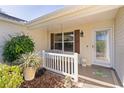 Inviting front porch with swing, perfect for relaxing and enjoying the outdoors. Decorative plants add to curb appeal at 1508 Lakewood Dr, The Villages, FL 32162