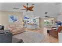 Spacious living room blends seamlessly with the kitchen, featuring tile floors, ceiling fans, and ample natural light at 1508 Lakewood Dr, The Villages, FL 32162