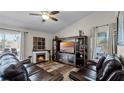 Inviting living room featuring a fireplace, entertainment center, and comfortable leather seating at 15307 Petrus Ln, Clermont, FL 34714