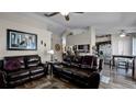 Open concept living area with leather sofas and a view into the adjacent kitchen and dining area at 15307 Petrus Ln, Clermont, FL 34714