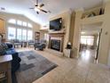 Cozy living room with fireplace, large windows, and tile flooring at 1670 Kensington Pl, The Villages, FL 32162