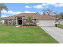 Charming single-story home with a well-manicured lawn and a two-car garage at 2214 Lake Pointe Cir, Leesburg, FL 34748