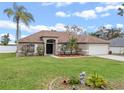 Charming single-story home with a well-manicured lawn, mature landscaping and a two-car garage at 2214 Lake Pointe Cir, Leesburg, FL 34748