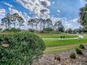 Scenic view of the lush green golf course with a smooth cart path on a clear sunny day at 2506 Greenhill Trl, The Villages, FL 32162