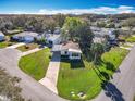 Aerial shot showcases the home's location within a well-maintained community, surrounded by lush greenery and a lake at 25546 Belle Alliance, Leesburg, FL 34748