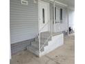 Inviting home entrance with steps, white railings, and gray siding for a clean and modern look at 263 Pinewood Dr, Eustis, FL 32726