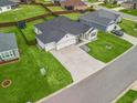 Aerial view of single Gathering home featuring a well-manicured lawn and a two car garage at 3318 Dzuro Dr, Oxford, FL 34484