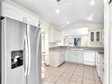 Bright kitchen featuring white cabinetry, modern stainless steel refrigerator, and a spacious layout at 4835 Kelso St, Leesburg, FL 34748