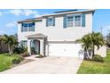 Two story home boasts a manicured lawn, blue shutters, solar panels, and a two car garage at 5363 Timberland Ave, St Cloud, FL 34771