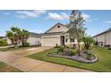 Charming single-story home with a two-car garage, stone accents, and well-manicured landscaping at 8677 Bridgeport Bay Cir, Mount Dora, FL 32757
