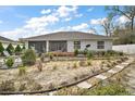 Spacious backyard with well-tended garden beds and a relaxing seating area on an open porch at 8721 Se 159Th Pl, Summerfield, FL 34491