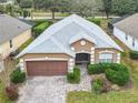 Aerial view of a well-maintained single-story house with a light gray roof and manicured landscaping at 1007 Balmoral Dr, Davenport, FL 33896