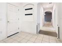 Bright entryway featuring white tile flooring, coat rack, and white walls leading to other rooms at 1007 Balmoral Dr, Davenport, FL 33896