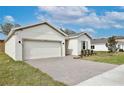 Side view of the beautiful home highlighting the brick driveway, lawn, and easy access garage at 1193 Stratton Ave, Groveland, FL 34736