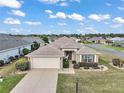 Beautiful aerial view of a single story home featuring manicured landscaping, a 2 car garage and neutral tones at 11945 Se 91St Cir, Summerfield, FL 34491