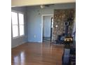 Inviting living room with hardwood floors, large windows, a decorative stone fireplace, and light blue walls at 13738 State Road 33, Groveland, FL 34736