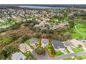 Aerial view of a home in a lovely neighborhood near a lake, surrounded by lush landscaping at 1415 Bethune Way, The Villages, FL 32162