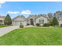 Charming single story home featuring a paver driveway, attached garage and manicured lawn at 1415 Bethune Way, The Villages, FL 32162