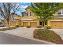 Charming exterior view of the yellow townhouse with lush green landscaping and driveway at 14157 Oasis Cove Blvd # 104, Windermere, FL 34786