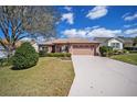 Charming home with a well-maintained lawn, long driveway, and mature landscaping at 1537 Eastover Ter, The Villages, FL 32162