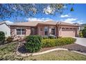 Charming home featuring a well manicured front yard, beautiful landscaping, and a two-car garage at 1537 Eastover Ter, The Villages, FL 32162