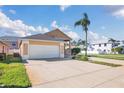 Attached two-car garage with concrete driveway surrounded by green grass at 16628 Citrus Pkwy, Clermont, FL 34714