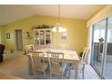 Bright dining room featuring vaulted ceilings, a chandelier, and access to the lanai at 17937 Se 107Th Ter, Summerfield, FL 34491