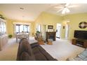 Bright living room featuring vaulted ceilings, a fireplace, and a ceiling fan at 17937 Se 107Th Ter, Summerfield, FL 34491