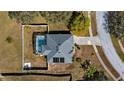 Aerial view of a single-Gathering home with a screened-in pool, fenced yard, and well-manicured landscaping at 1801 Summit Oaks Cir, Minneola, FL 34715