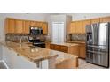 Well-equipped kitchen featuring stainless steel appliances, granite countertops, and ample wood cabinetry at 1801 Summit Oaks Cir, Minneola, FL 34715