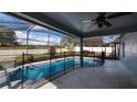 Relaxing screened-in pool area with clear blue water, complemented by an enclosed safety fence and outdoor space at 1801 Summit Oaks Cir, Minneola, FL 34715