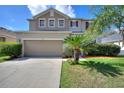 Charming home with a well-maintained lawn, a two-car garage, and lush landscaping at 201 Andover Dr, Davenport, FL 33897