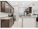 Well-lit kitchen featuring granite counters, stainless steel appliances, and tile flooring. Dining room view at 215 Elm Ct, Kissimmee, FL 34759