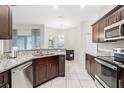 Modern kitchen with stainless steel appliances, granite countertops, and tiled floors at 215 Elm Ct, Kissimmee, FL 34759