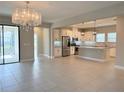 Open concept living room with tile floors flowing into a modern kitchen with stainless appliances at 2313 Hamilton Ridge Road, Clermont, FL 34715